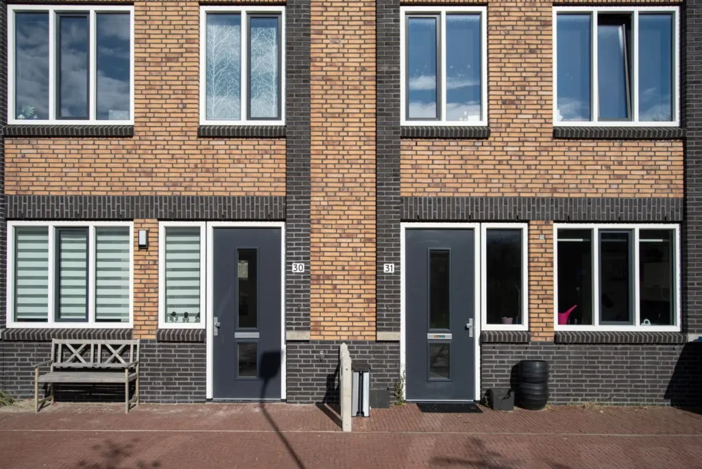 Bakstenen woningen met nieuwe kozijnen en voordeuren
