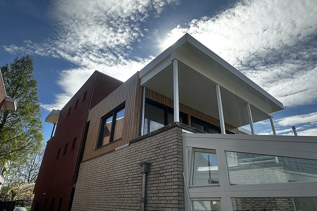 Moderne uitbouw met zwarte kozijnen en grote glazen pui