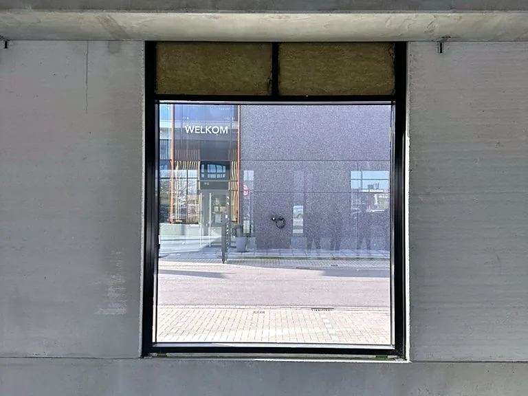 Zwart aluminium kozijn in een betonnen bedrijfsruimte